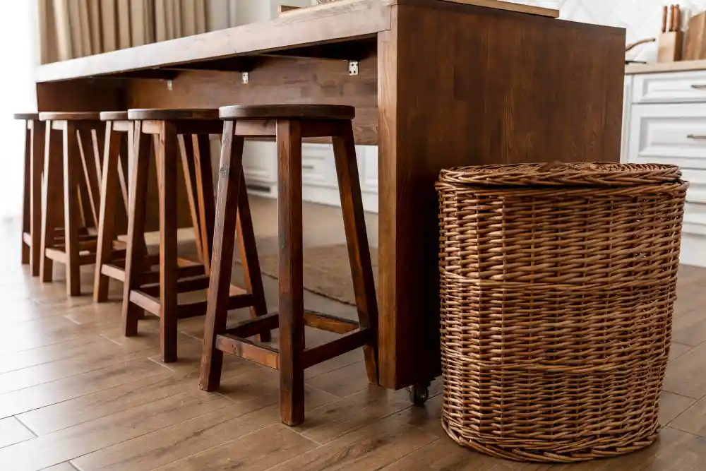 Wooden dining stools placed under a modern wooden kitchen island table.