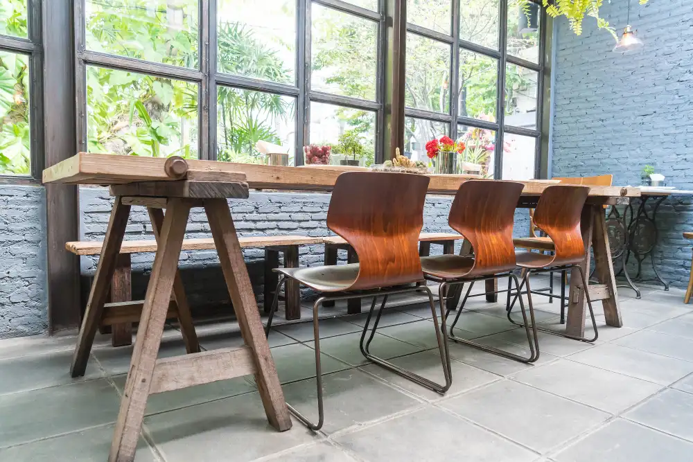 Wooden dining table with chairs and bench in stylish interior