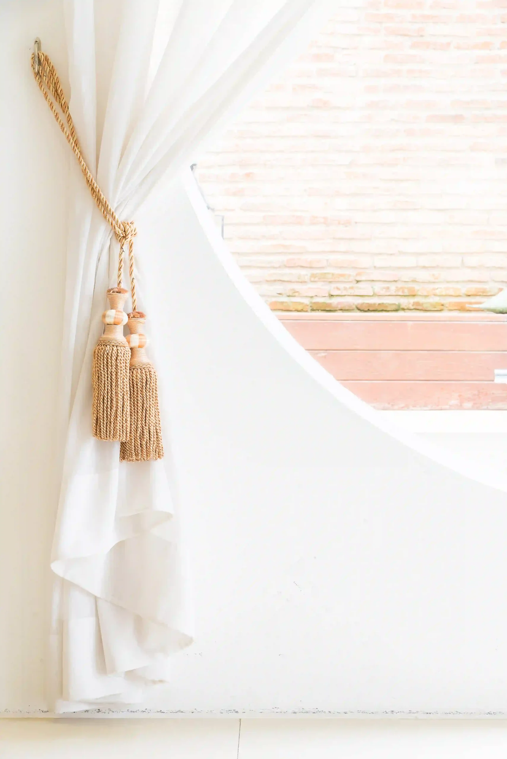"Elegant curtains hanging over a window, filtering natural light and enhancing interior decor."