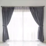 Elegant beige home curtains with soft fabric and modern design hanging in a bright living room, adding style and warmth to the interior.