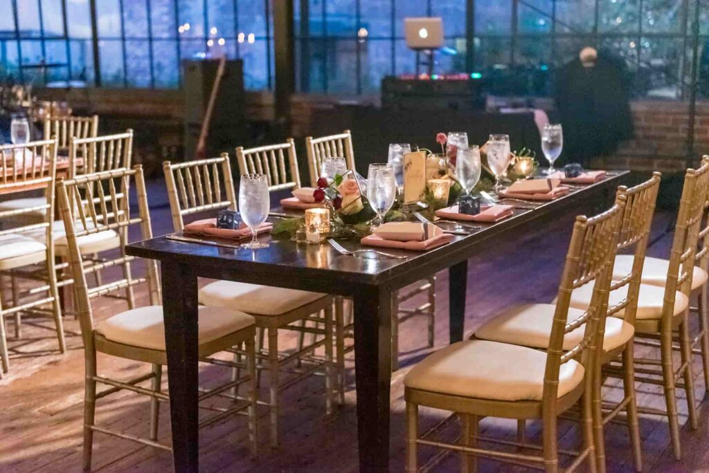 **Alt text:** Elegant dining table setup with gold chairs, candles, and glassware in a stylish restaurant dining space.
