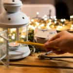 A warm, glowing oil lantern placed on a rustic wooden table during an evening outdoor gathering, showcasing how the soft amber light creates a cozy and inviting atmosphere for camping or backyard events.