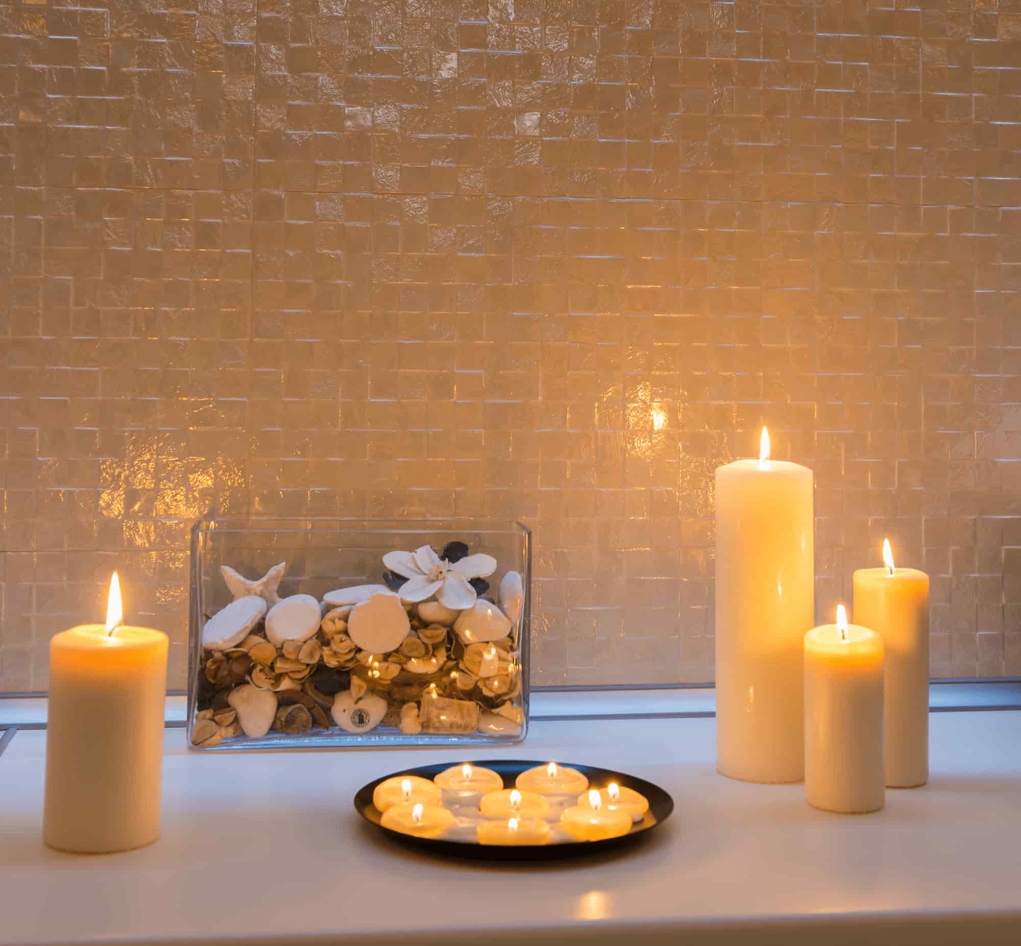 Elegant candle decoration with white pillar candles and tea lights for romantic dinner table setup
