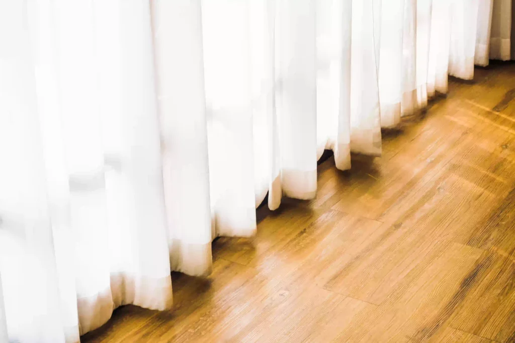 Long curtains touching the floor in a stylish bedroom interior