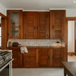 Traditional kitchen with rich brown solid wood cabinets, white tile backsplash, stainless steel gas range, and natural light from wooden framed windows